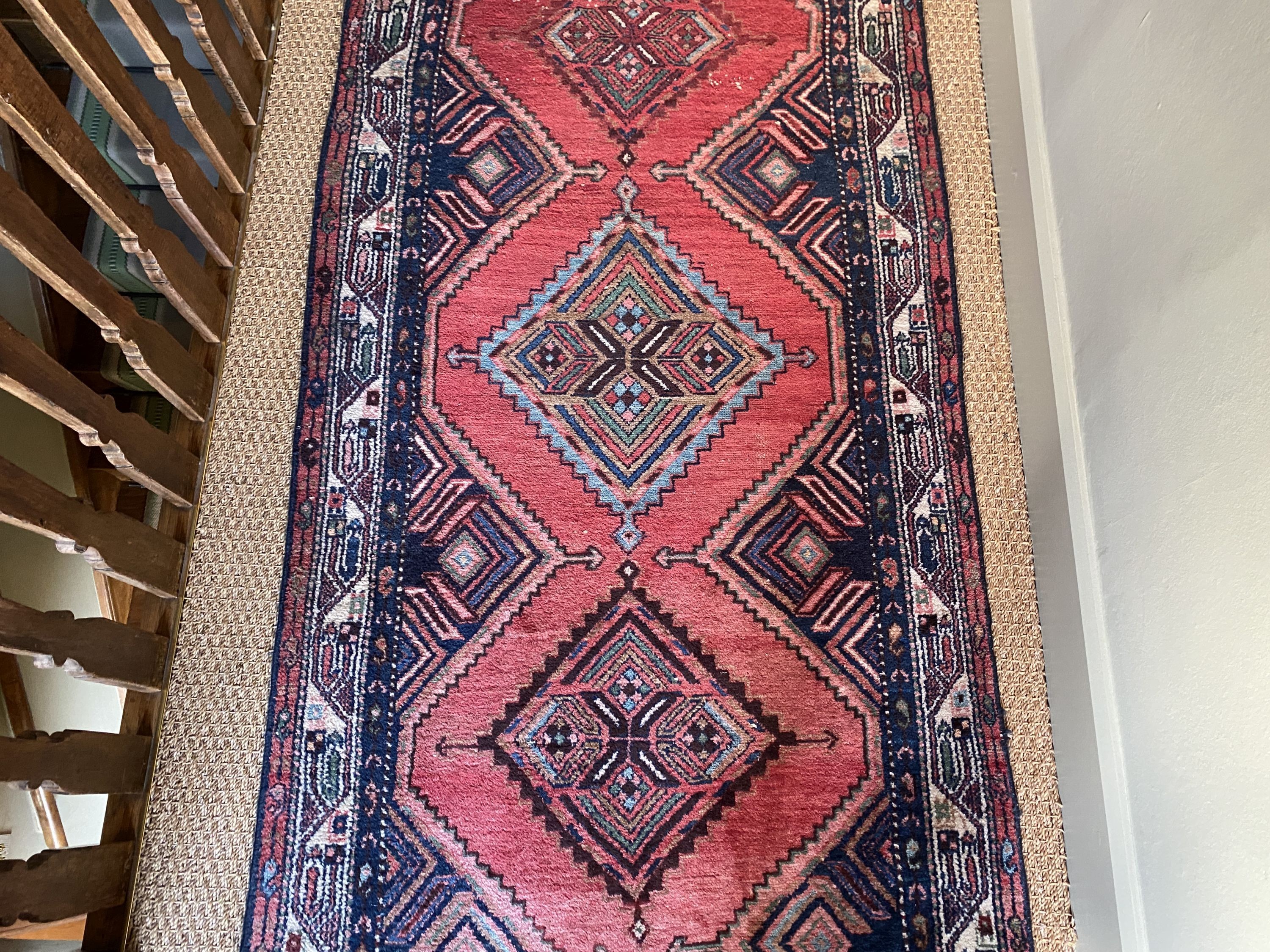 A Persian red ground runner, with five central lozenges, multi-bordered, 303 x 98cm